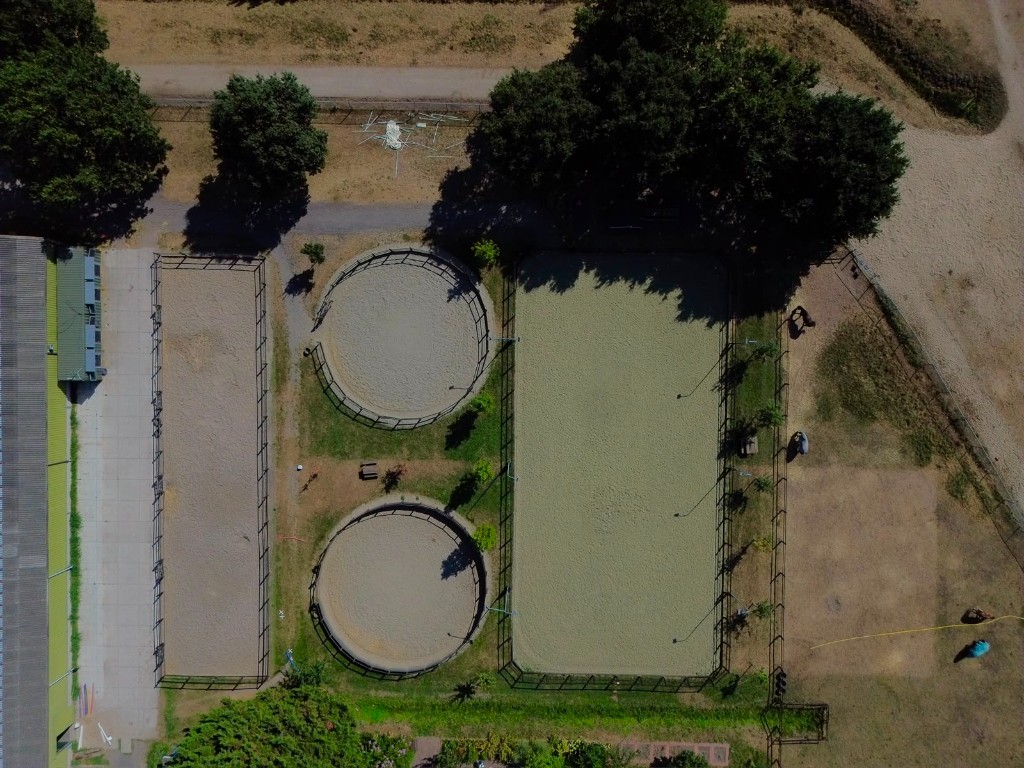 Luchtfoto van longeercirkels en rijbanen op het terrein