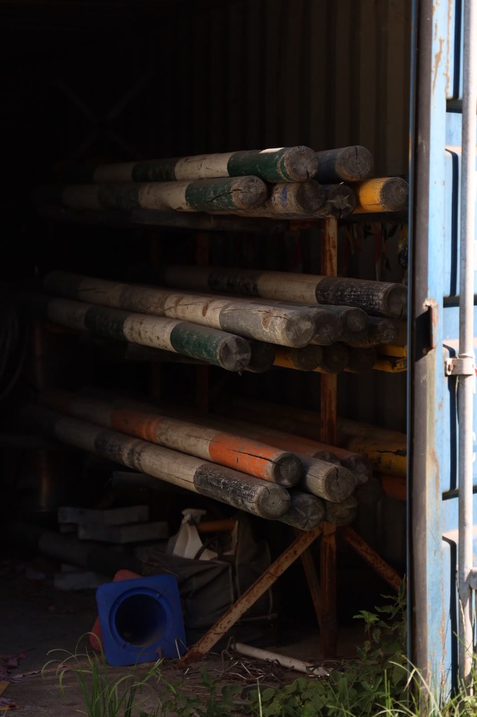 Springbalken en polenpalen in de materiaalcontainer